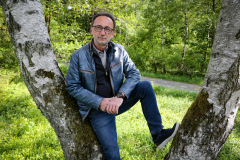 Lutz Scheufler angelehnt an eine Birke im Wald